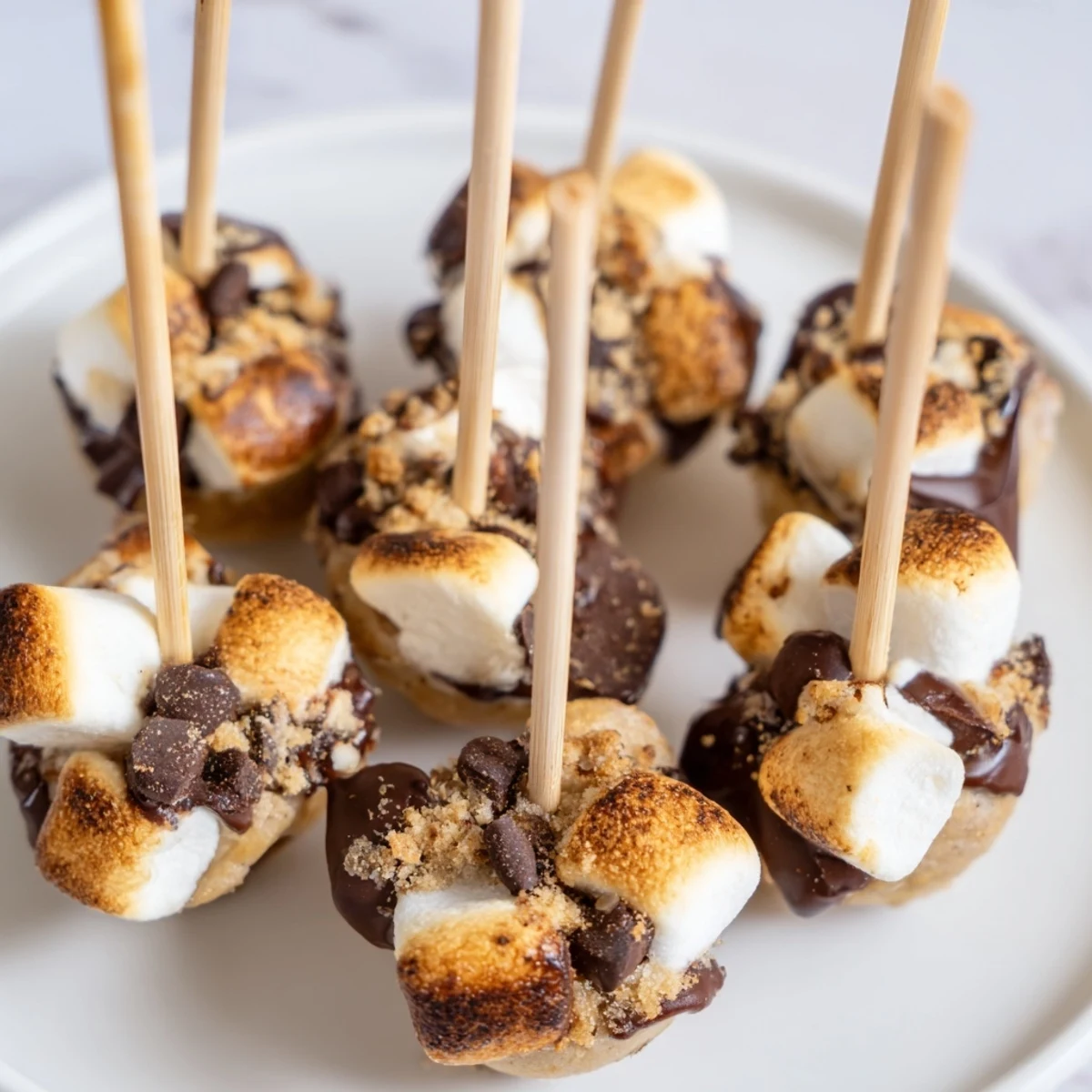 Delicious Smores Cinnamon Sweet Tea Muffin Pops coated in chocolate and mini marshmallows.  