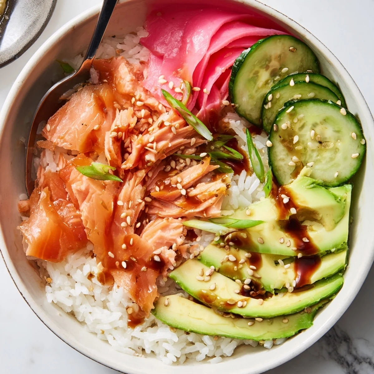 Delicious Leftover Salmon & Rice Bowl topped with avocado and cucumber slices.  