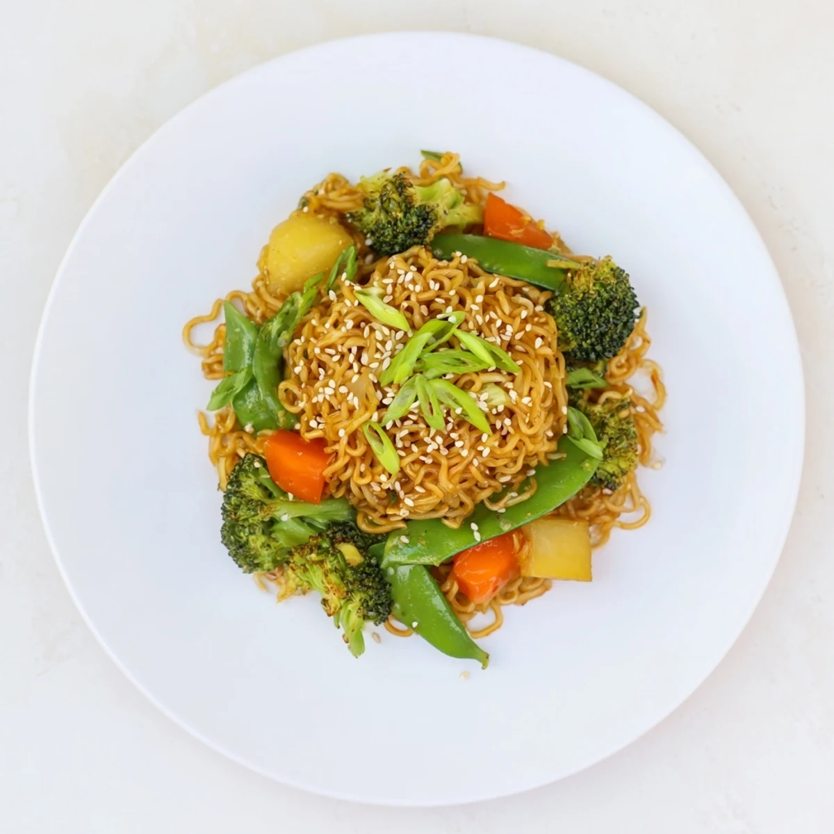 Steaming bowl of Ramen Noodle Stir-Fry Remix with vibrant vegetables and sesame seeds, ready to savor.
