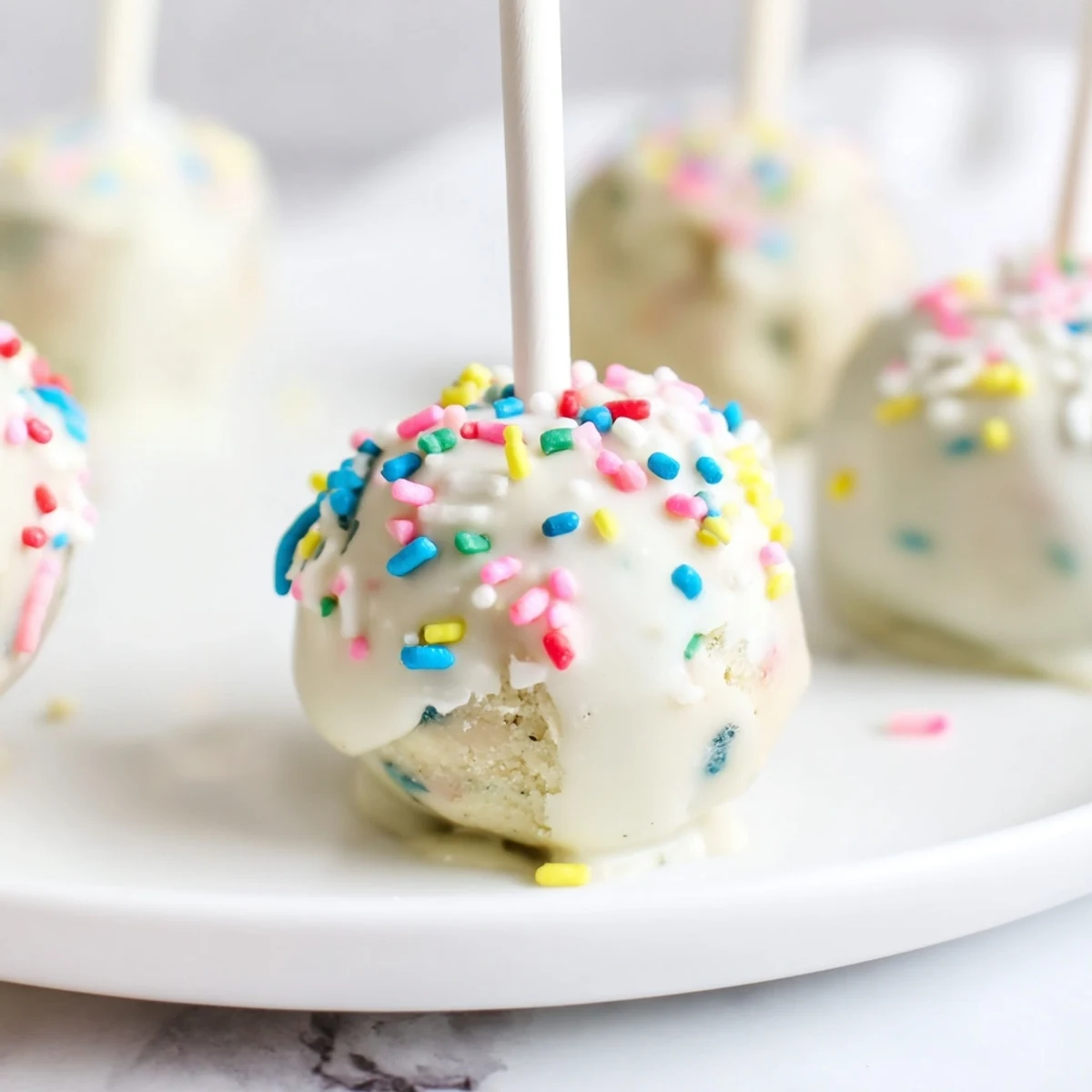 Lightened-Up Sugar Cookie Cake Pops, a decadent dessert, beautifully coated and ready to enjoy.