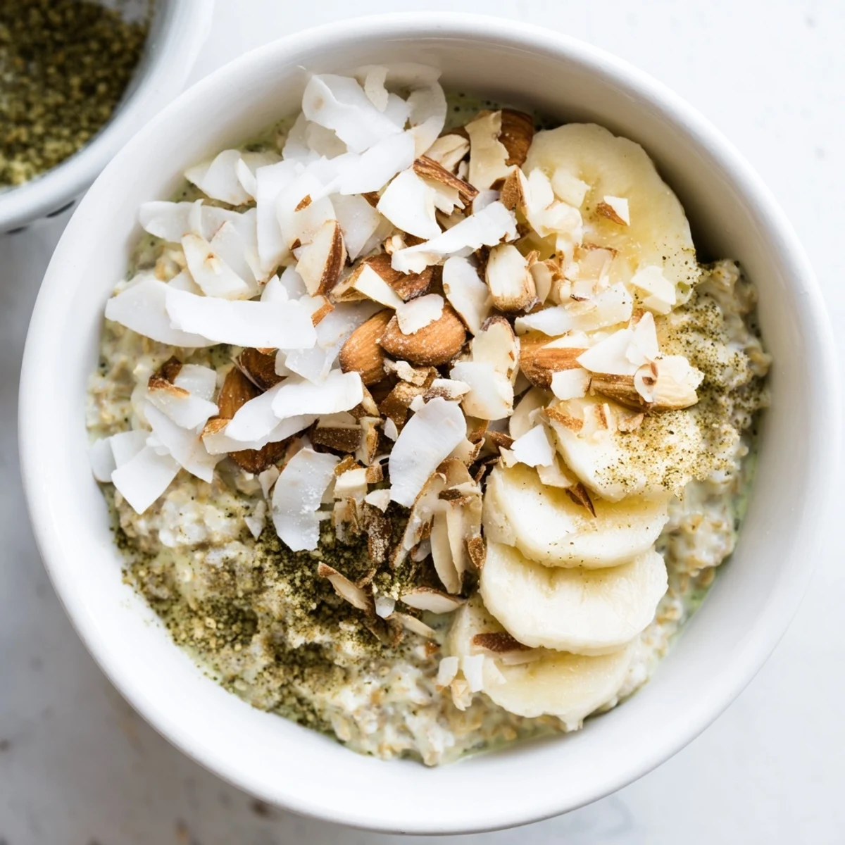 A close-up of High-Protein Eggnog Matcha Overnight Oats, highlighting the layered, thick, green breakfast.