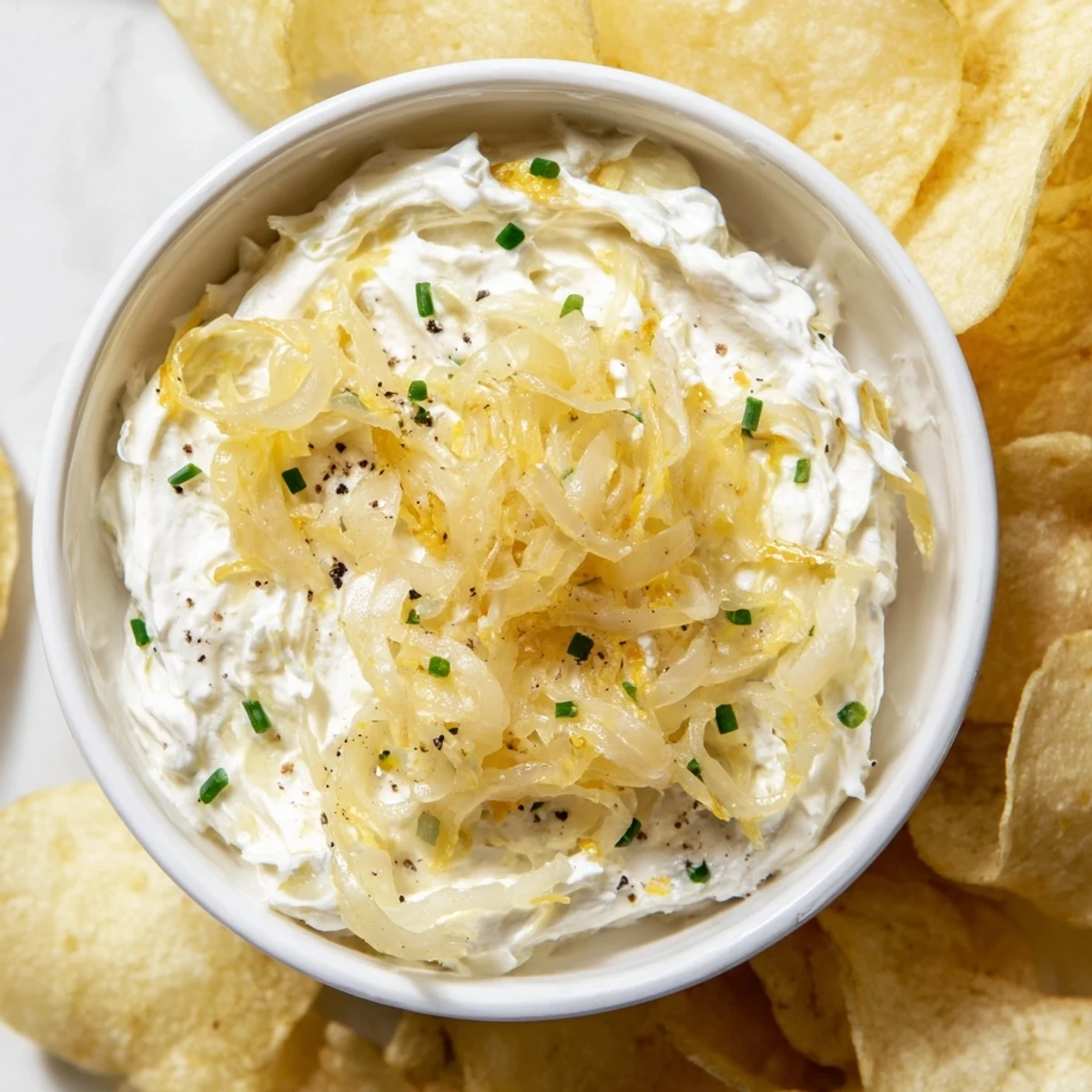 Golden, crunchy potato chips ready to be dipped into a creamy, savory homemade onion dip.