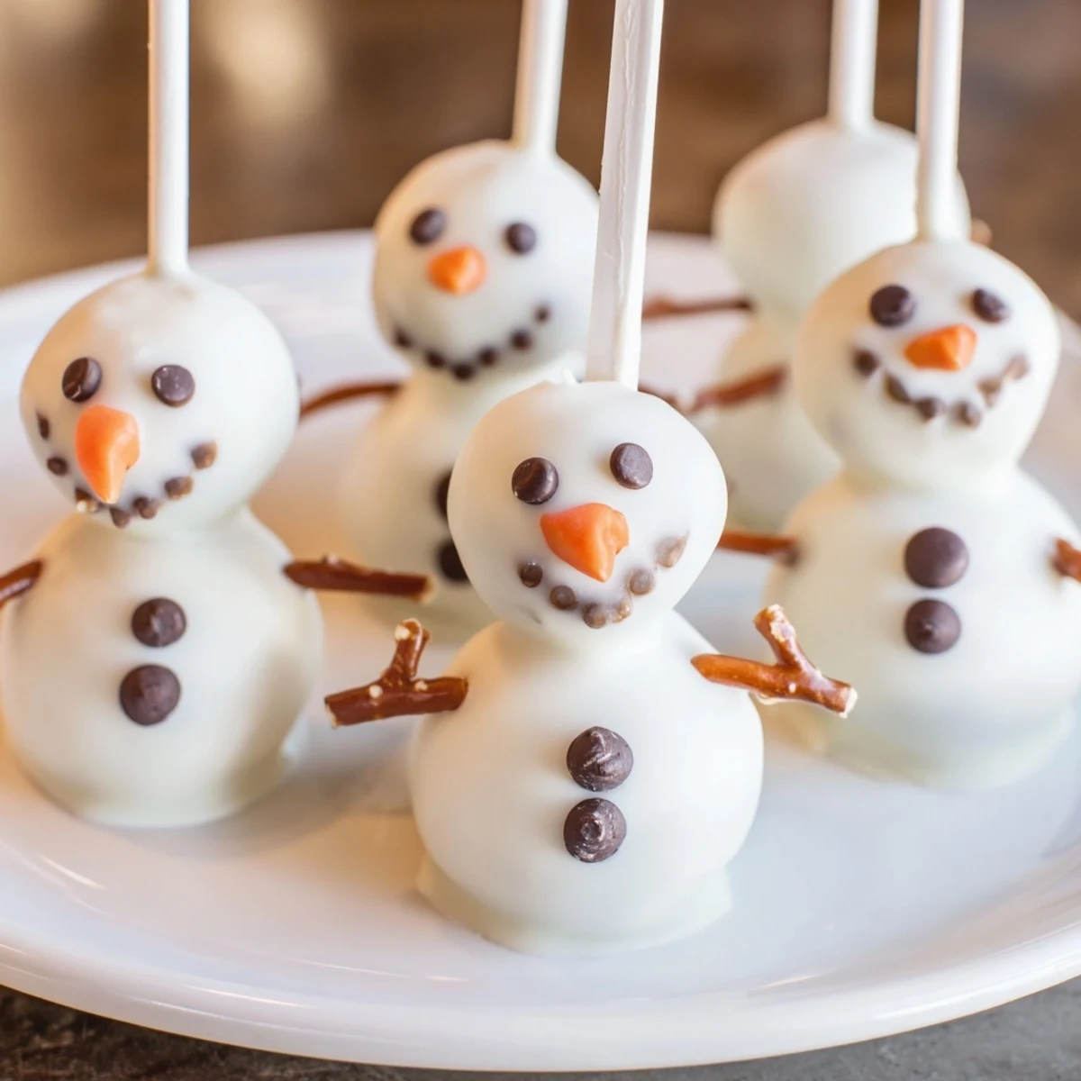 Oreo Snowman Cake Pops, coated in white chocolate, ready for a winter holiday party.