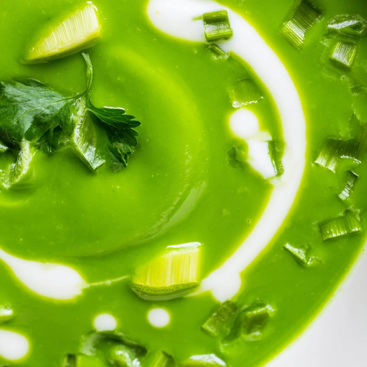 Creamy Spinach Coriander Lemongrass Soup served in a white bowl, garnished with cilantro leaves and lime wedges.  