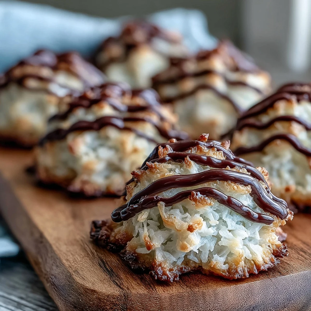A close-up shows a chewy Vegan Coconut Macaroon half-dipped in rich, melted dark chocolate.
