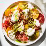 A colorful Heirloom Tomato Salad Board featuring fresh tomatoes, soft burrata, and fragrant basil dressing.