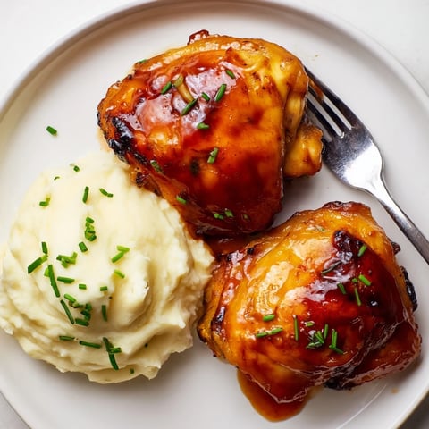 Succulent honey BBQ chicken thighs glazed in sauce, paired with creamy garlic mashed potatoes. 