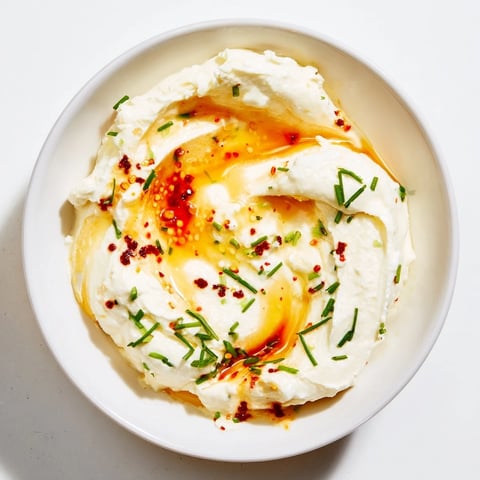 Creamy whipped ricotta dip with a luscious hot honey swirl, ready to be scooped up.