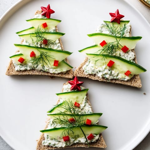 Cucumber and cream cheese tree stacks displayed with red pepper "ornaments" offer a festive appetizer for your event.