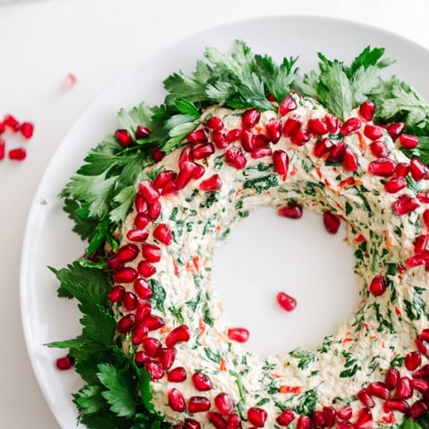 Vibrant homemade red pepper and spinach dip wreath, a beautiful holiday appetizer, ready to serve.