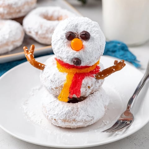 Stacked mini donut snowman recipe, a festive and fun winter treat ready to enjoy.
