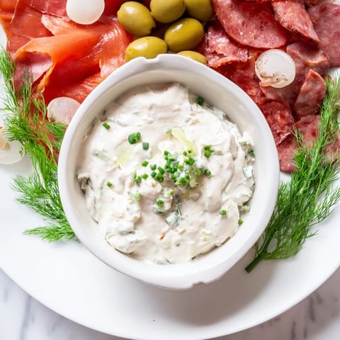 A delectable Compass Rose appetizer: smoked salmon, chorizo, prosciutto, and roast beef circling a creamy dip.
