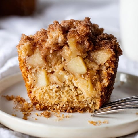 Warm, comforting Apple Cinnamon Muffins, streusel crumb topping visible, ready to enjoy with coffee.