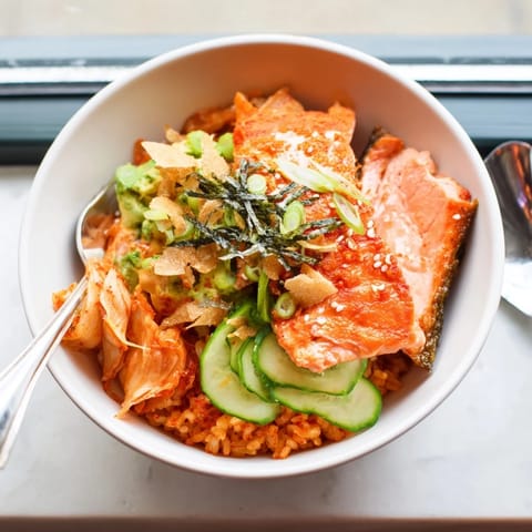 Flavorful crispy salmon rice bowl garnished with fresh vegetables and zesty spicy mayo.  