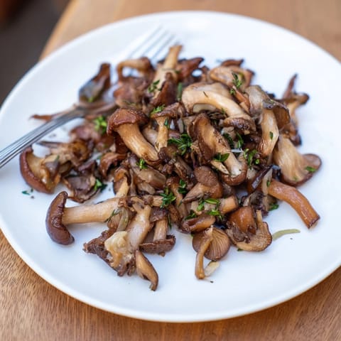 A close-up view of flavorful Enchanted Forest Mushrooms, sautéed to perfection with garlic and thyme.