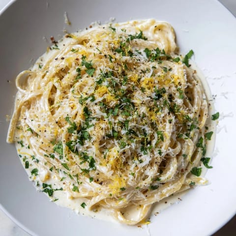A close-up of Lemon-Garlic Greek Yogurt Pasta, glistening with lemon and garlic sauce; delicious!