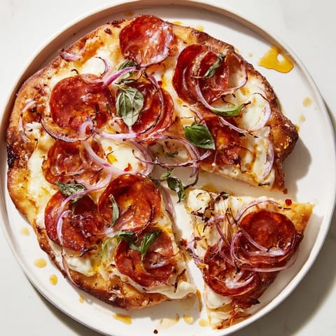 Golden brown hot honey pepperoni flatbread, featuring crispy flatbread and fresh basil garnish.