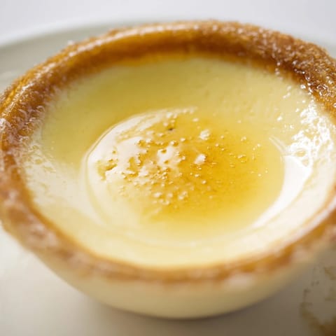 Creamy, chilled lemon brûlée posset with a crackling sugar crust, perfect for a special treat.