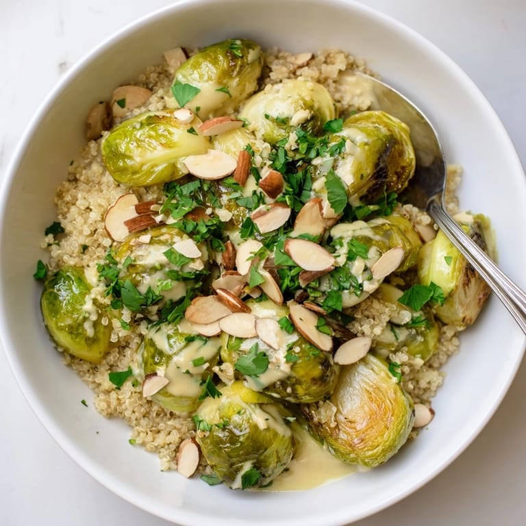 Close-up of Alfredo Roasted Brussels Sprouts Bowl, featuring toasted almonds and fresh parsley.