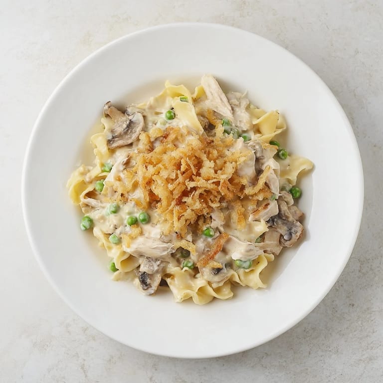 A warm, homestyle serving of Creamy Tuna Noodle Casserole, complete with crispy onion topping.