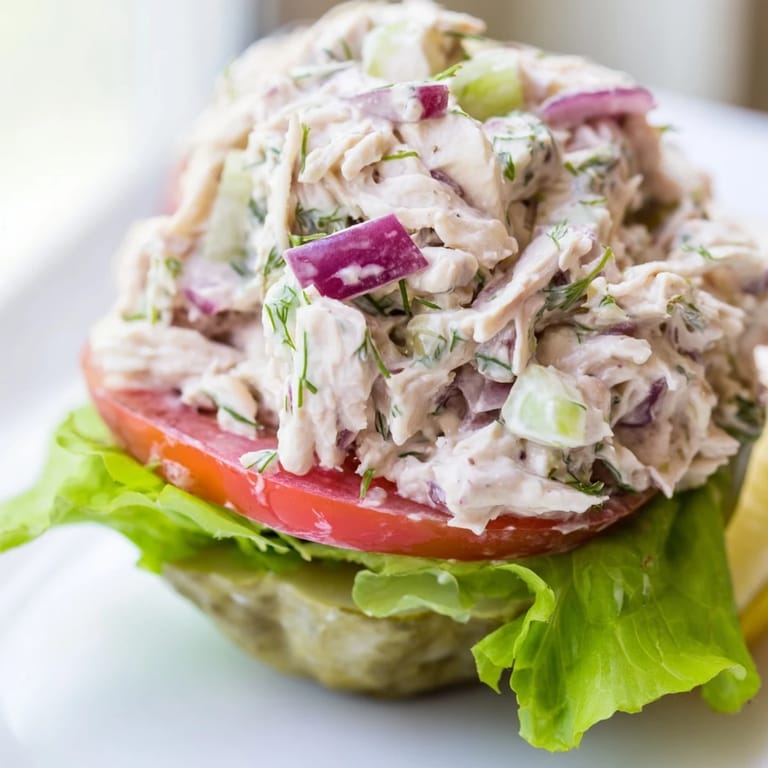 A visually appealing pickle sandwich showcasing juicy chicken salad inside a hollowed-out pickle.