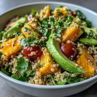 Tropical mango avocado quinoa salad with lime dressing, featuring juicy mango cubes, creamy avocado slices, and fluffy quinoa, tossed in a zesty citrus dressing.