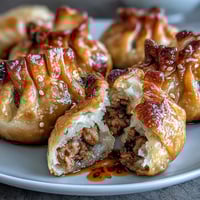 Crispy air fried pork dumplings served with a vibrant, spicy chili oil dipping sauce for an irresistible appetizer.  