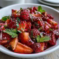 Vibrant strawberry lemonade fruit salad with fresh berries, juicy grapes, and pineapple in a zesty lemon-honey dressing.